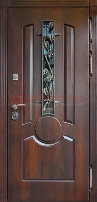 Темная железная дверь со стеклом и ковкой для кирпичного дома ДСК-136 в Челябинске